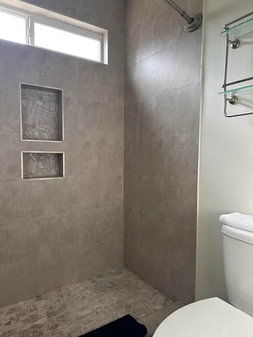 a bathroom with a toilet and a shower