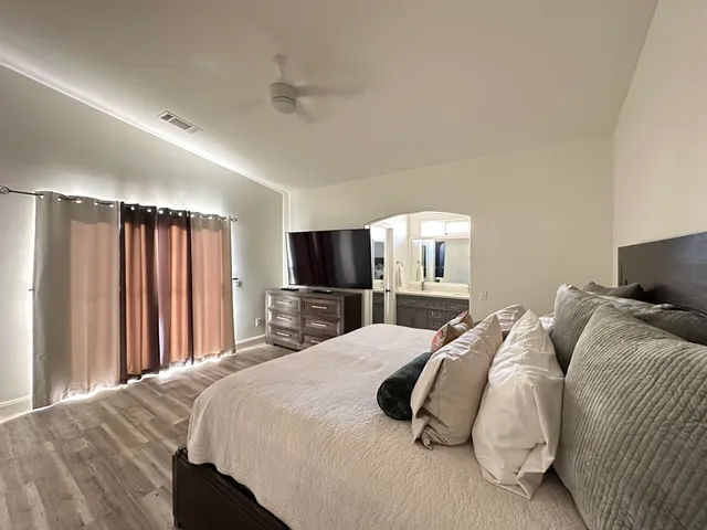 a bedroom with a bed and a flat screen tv