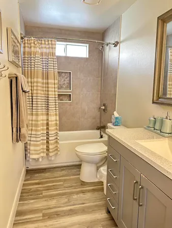 a bathroom with a sink a toilet and shower