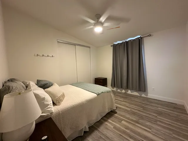 a bedroom with a bed and a ceiling fan