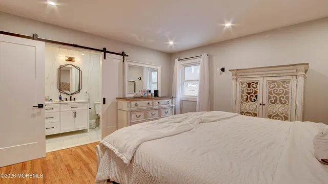 a bedroom with a bed a dresser and mirror