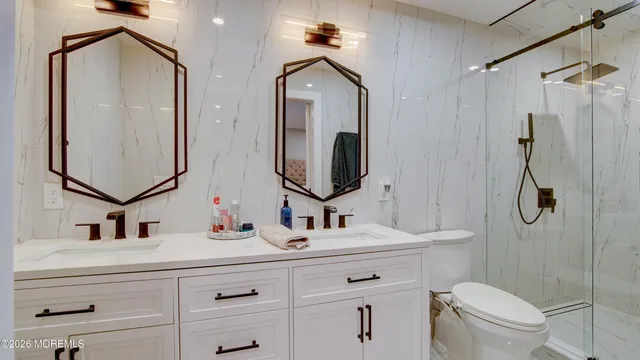 a bathroom with a double vanity sink mirror and toilet