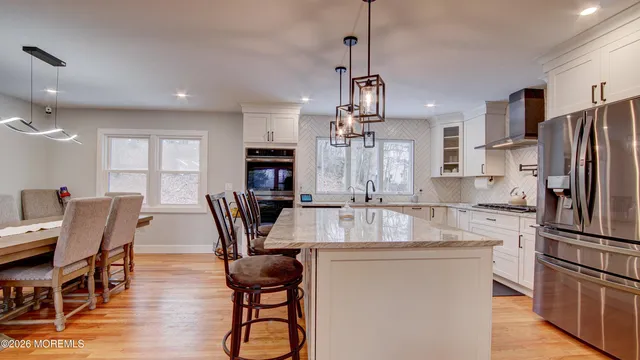 a dining room with furniture a chandelier and wooden floor