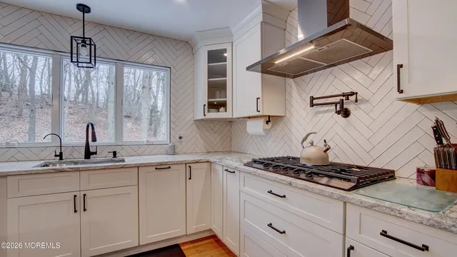 a kitchen with stainless steel appliances granite countertop a sink stove and cabinets