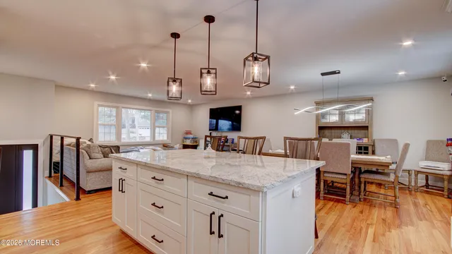 a open kitchen with stainless steel appliances granite countertop a stove and a wooden floor