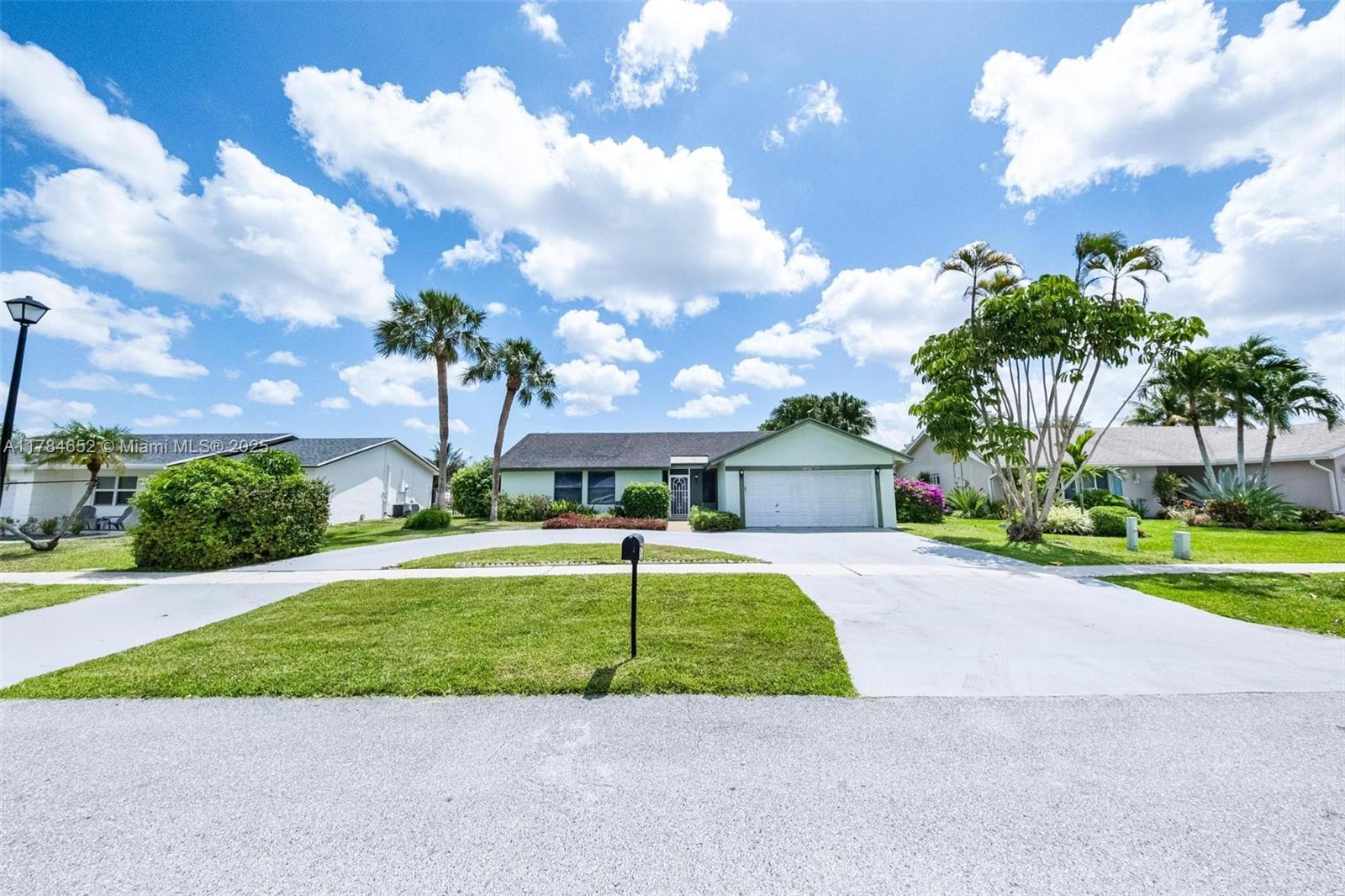 19476 Carolina Circle Boca Raton, FL 33434 - Photo 4 of 52 a front view of a house with a yard and garage