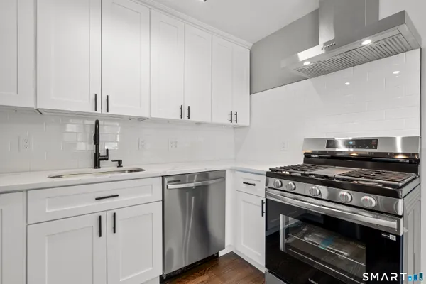 a kitchen with white cabinets and appliances
