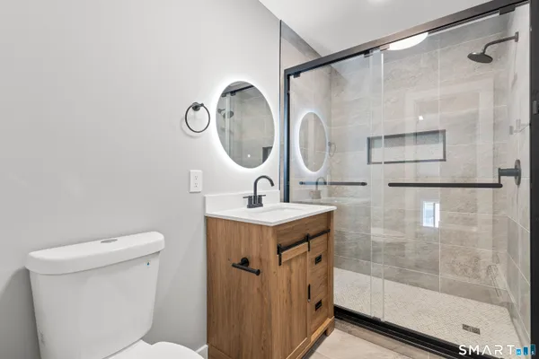 a bathroom with a sink mirror vanity and toilet
