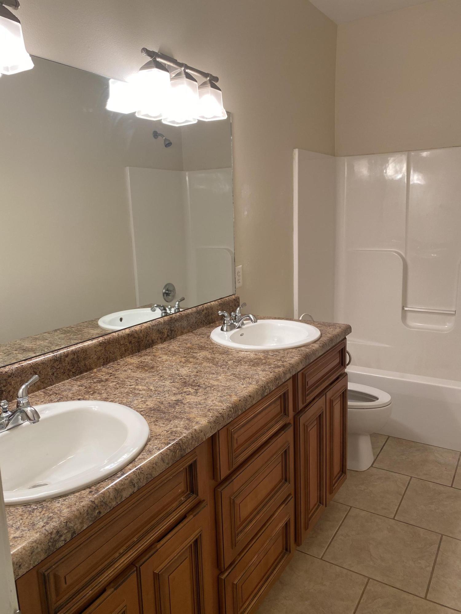 239 County Line Road Niceville, FL 32578 - Photo 15 of 36 a bathroom with a granite countertop sink a toilet a mirror and shower