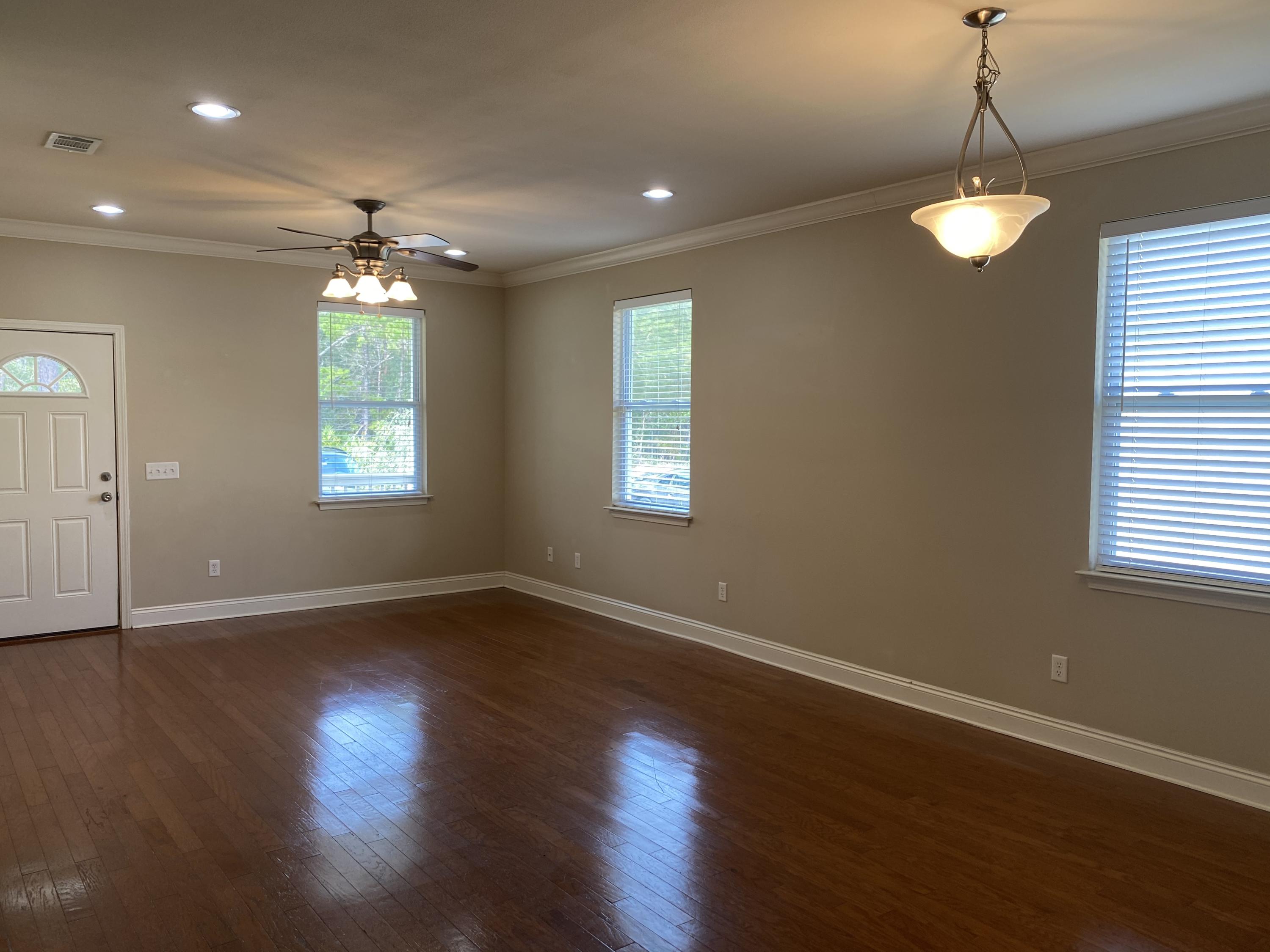 239 County Line Road Niceville, FL 32578 - Photo 4 of 36 an empty room with wooden floor and windows
