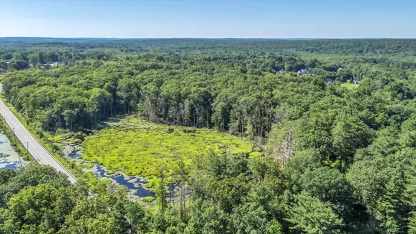 an aerial view of residential houses with outdoor space and trees
