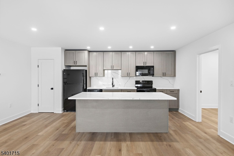 556 Main Street, Unit 2 Orange, NJ 07050 - Photo 4 of 9 a large kitchen with stainless steel appliances a large counter top a stove and a refrigerator