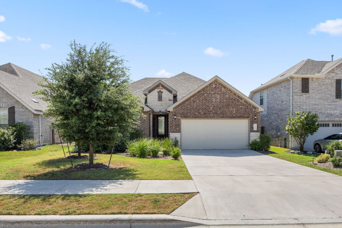 a front view of a house with a yard and garage