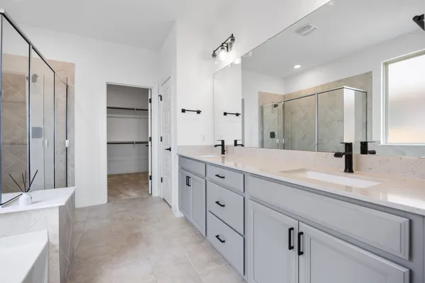 a spacious bathroom with double sink and shower