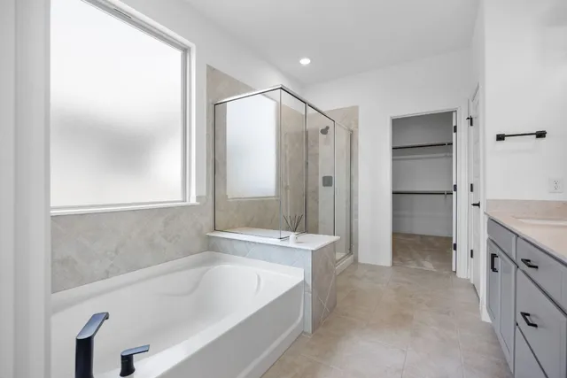 a bathroom with a bathtub and a double vanity sink