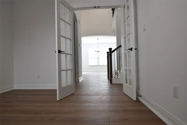 a view of a hallway with wooden floor and closet