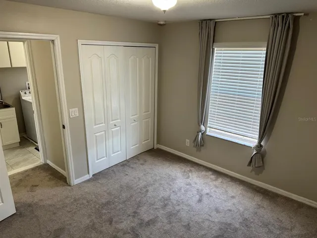 an empty room with closet and mirrors