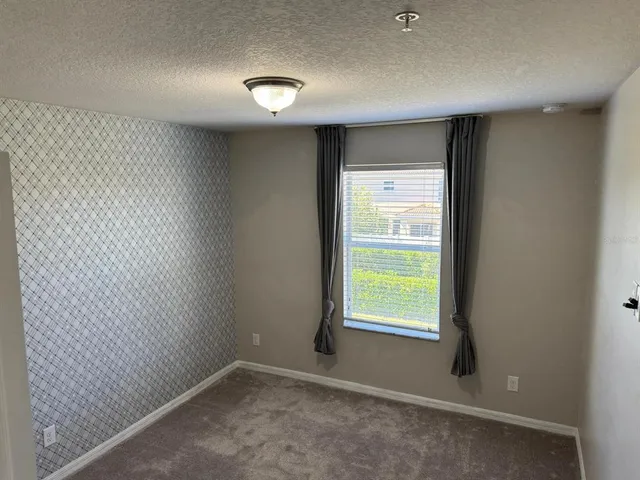 a view of an empty room with glass door and windows