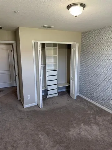 a view of a hallway with windows and chandelier