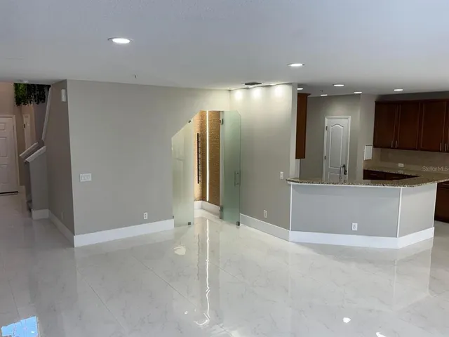 a kitchen with granite countertop wooden cabinets a refrigerator and a sink