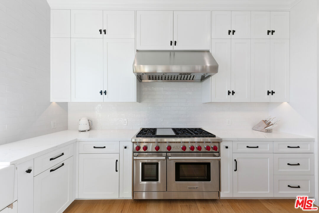 26575 Ocean View Drive Malibu, CA 90265 - Photo 11 of 40 a kitchen with white cabinets and white appliances