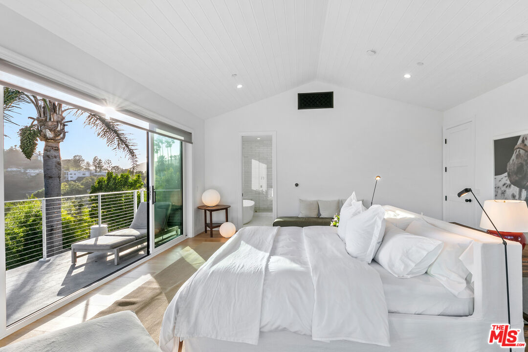 26575 Ocean View Drive Malibu, CA 90265 - Photo 14 of 40 a bedroom with a large bed and a large window
