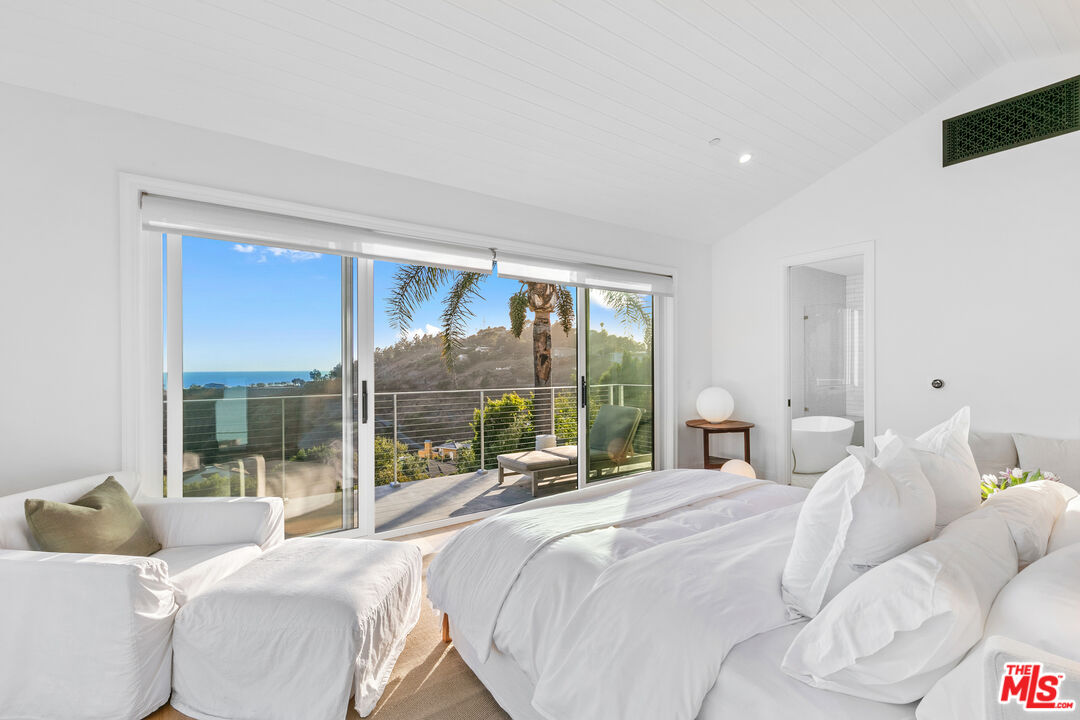 26575 Ocean View Drive Malibu, CA 90265 - Photo 16 of 40 a bedroom with a bed and a large window