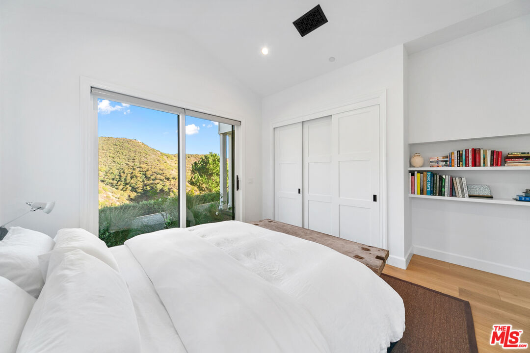 26575 Ocean View Drive Malibu, CA 90265 - Photo 26 of 40 a bedroom with a bed and a large window