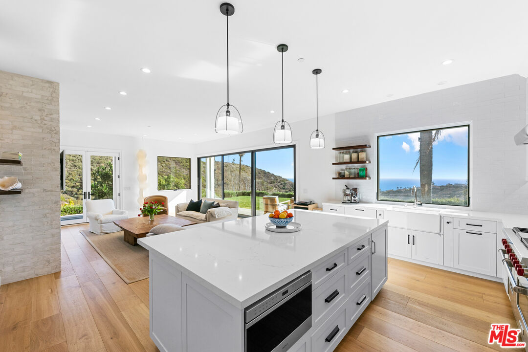 26575 Ocean View Drive Malibu, CA 90265 - Photo 8 of 40 a kitchen with stainless steel appliances granite countertop a sink and a wooden floor