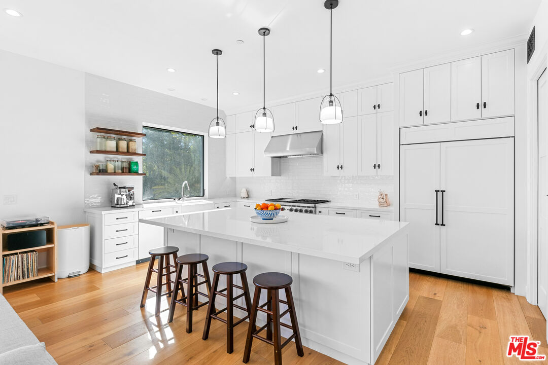 26575 Ocean View Drive Malibu, CA 90265 - Photo 10 of 40 a kitchen with white cabinets and white appliances