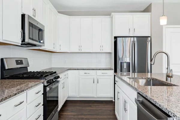 a kitchen with granite countertop a sink stove and cabinets