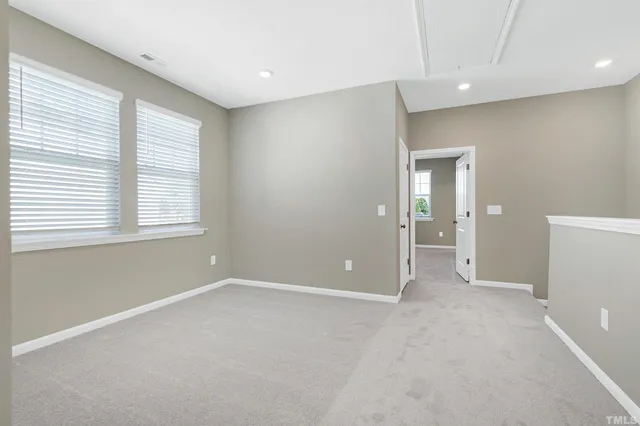 a view of an empty room with window and bathroom