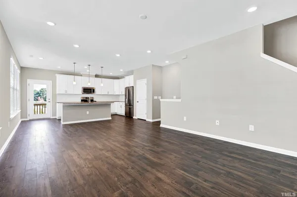 a view of kitchen with refrigerator stove and cabinets