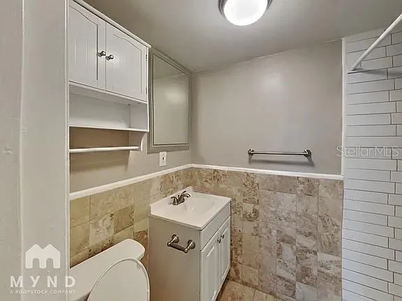 an empty room with wooden floor closet and windows