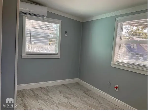 an empty room with windows and fan