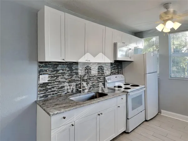 a view of a kitchen with a sink and a refrigerator