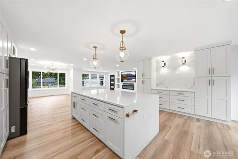 a kitchen with white cabinets and window
