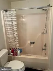 a bathroom with a shower curtain and a toilet