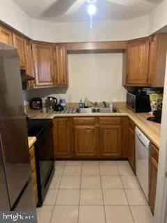 a kitchen with a sink a stove top oven a refrigerator and cabinets
