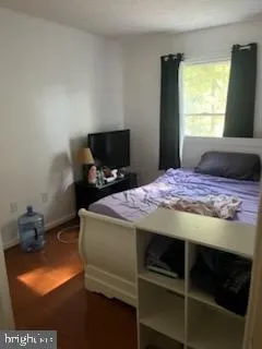 a bedroom with a bed and a tv on the dresser