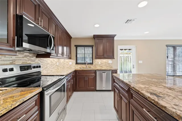 a kitchen with stainless steel appliances granite countertop a stove microwave and sink