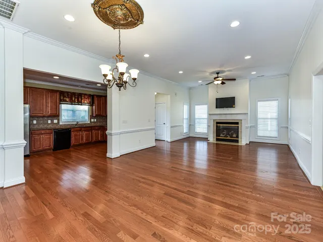 a view of a livingroom with a fireplace wooden floor and chandelier