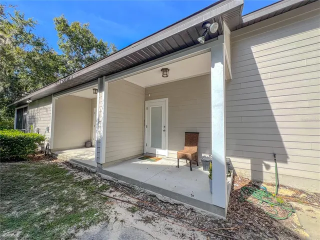 a view of a house with backyard and sitting area