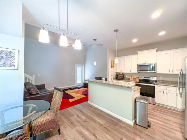 a kitchen with kitchen island a stove and a wooden floor