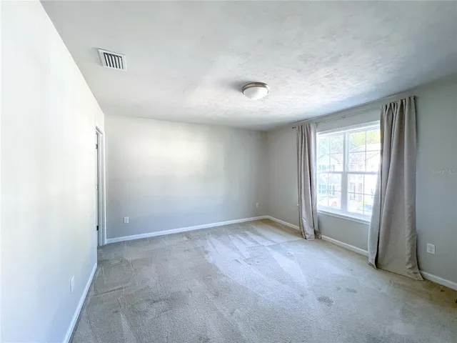 an empty room with windows and closet