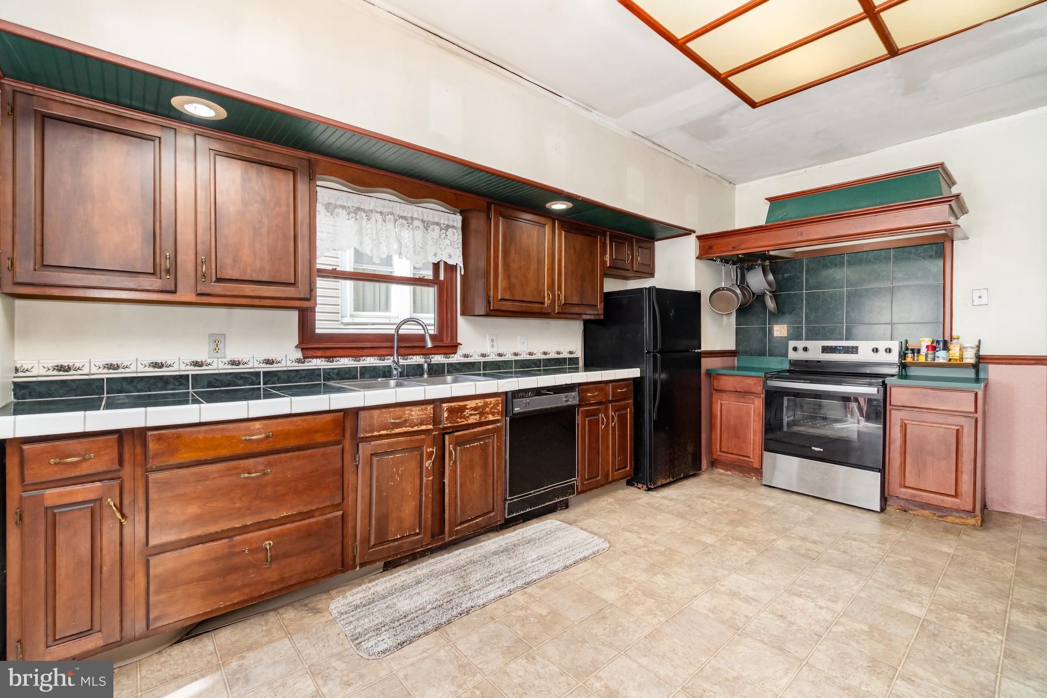 162 Swatara Road Shenandoah, PA 17976 - Photo 12 of 37 a kitchen with granite countertop wooden cabinets stainless steel appliances a sink and a window