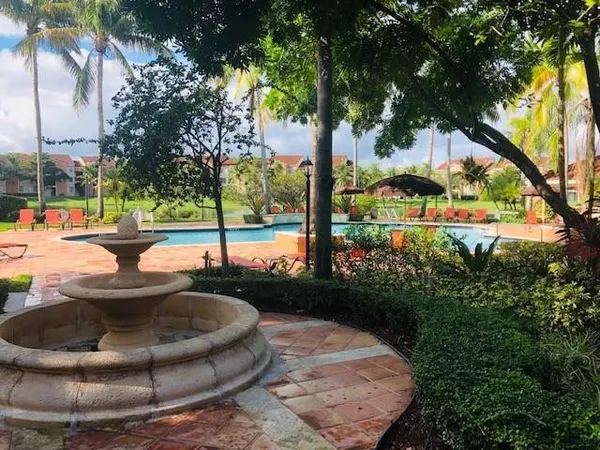 a view of a lake with boats and palm trees