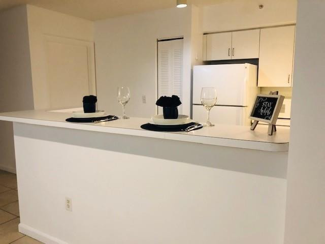 2011 Renaissance Boulevard, Unit 103 Miramar, FL 33025 - Photo 3 of 25 a kitchen with a sink a counter and a refrigerator