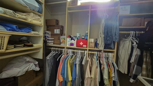 a view of walk in closet with clothes and shoes