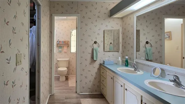 a bathroom with a granite countertop sink mirror and a shower